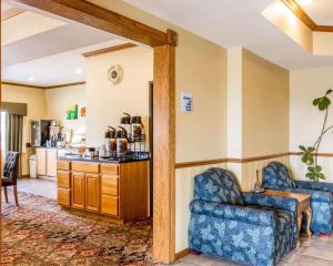 ein Wohnzimmer mit 2 blauen Stühlen und eine Küche in der Unterkunft Quality Inn in Pontiac