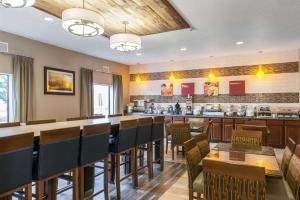 a restaurant with a bar with chairs and a counter at Comfort Suites in Vincennes