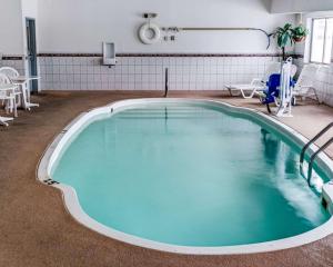 - une grande piscine dans une pièce dotée de tables et de chaises dans l'établissement Comfort Inn & Suites North Greenfield, à Greenfield