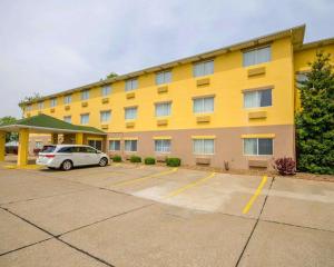 a large yellow building with a car parked in a parking lot at Quality Inn Evansville Eastland Area in Evansville