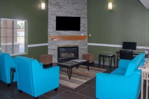 a living room with blue chairs and a fireplace at Quality Inn North Vernon near Hwy 50 in North Vernon