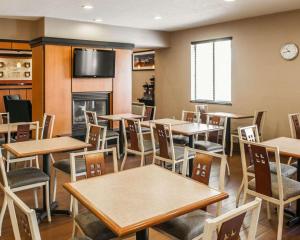 um restaurante com mesas e cadeiras e uma lareira em Quality Suites NE Indianapolis Fishers em Fishers