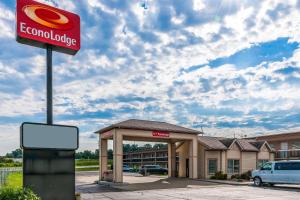 a gas station with a sign in front of a building at Econo Lodge Vincennes in Vincennes