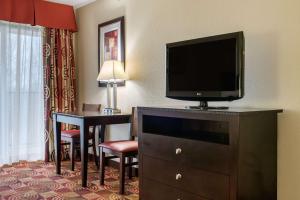 a hotel room with a television on a dresser with a desk at Quality Inn Bloomington Near University in Bloomington