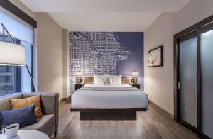 a hotel room with a large bed and a painting on the wall at Cambria Hotel Chicago Loop/Theatre District in Chicago