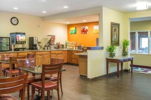 a restaurant with a table and chairs and a kitchen at Quality Inn & Suites Bloomington I-55 and I-74 in Bloomington