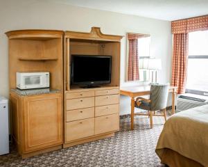 a hotel room with a television and a bedroom at Quality Inn & Suites Greenfield I-70 in Greenfield