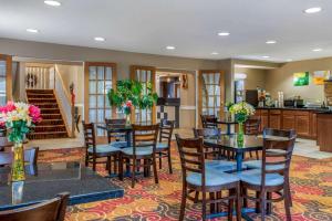 a dining room with tables and chairs and a kitchen at Quality Inn Bloomington Near University in Bloomington