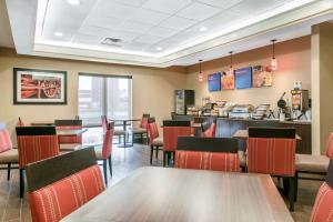a restaurant with tables and chairs and a counter at Comfort Inn & Suites Porter near Indiana Dunes in Porter