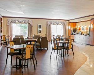 a restaurant with tables and chairs and a kitchen at Comfort Suites Southport in Southport