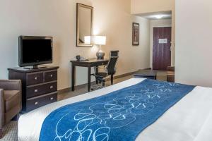 a hotel room with a bed and a desk and a television at Comfort Suites South Bend Near Casino in South Bend