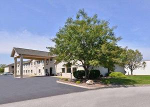 a large white building with a tree in front of it at Express Inn & suites in Decatur