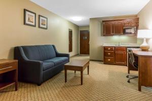 a living room with a blue couch and a kitchen at Comfort Inn & Suites Mishawaka-South Bend in South Bend