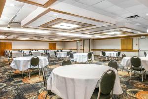 - une salle de banquet avec des tables et des chaises blanches dans l'établissement Quality Inn Conference Center Logansport, à Logansport