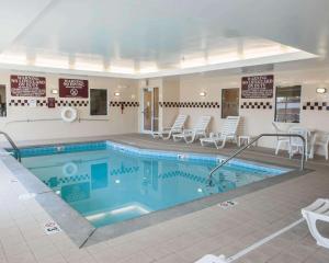a large swimming pool with chairs and tables in a building at Comfort Suites Southport in Southport