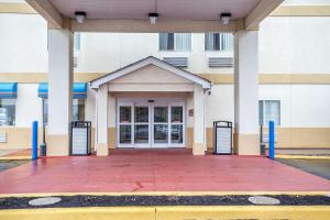 a front door of a building with blue columns at Comfort Inn Schererville in Schererville