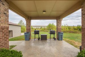 a patio with three trash cans and two chairs at Suburban Studios Clarksville-Louisville North in Clarksville