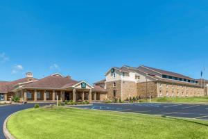 a large building with a lawn in front of it at Quality Inn & Suites Bedford West in Bedford