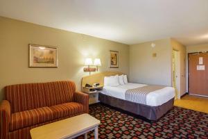 una camera d'albergo con letto e divano di Suburban Studios Clarksville-Louisville North a Clarksville