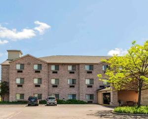 un gran edificio de ladrillo con dos coches estacionados en un estacionamiento en Comfort Inn Avon-Indianapolis West, en Avon