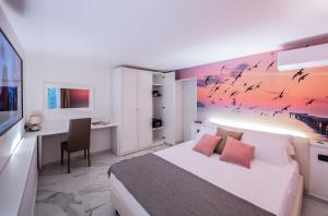 a bedroom with a bed and a desk with a computer at Marina Centro Suite in Rimini
