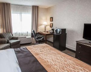 Habitación de hotel con cama, escritorio y TV. en Quality Inn Seekonk-Providence en Seekonk