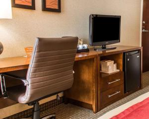 a room with a desk with a computer monitor and a chair at Comfort Inn Boston in Boston