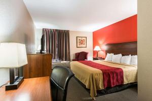 a hotel room with a bed and a red wall at Econo Lodge Andrews AFB in Clinton