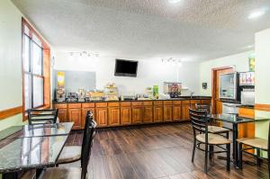 La Casa Inn & Suites-Middleboro في ميدلبورو: غرفة طعام بها طاولات وكراسي وتلفزيون