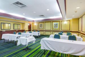una sala de conferencias con mesas blancas y sillas azules en Quality Inn Boston-Revere en Revere
