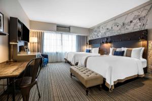 a hotel room with two beds and a table and chairs at enVision Hotel Boston-Everett in Boston