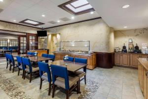 une salle à manger avec des tables et des chaises bleues dans l'établissement Comfort Inn Conference Center Bowie, à Bowie
