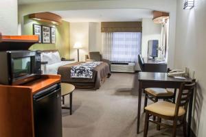 a hotel room with a bed and a desk at Sleep Inn & Suites in Emmitsburg