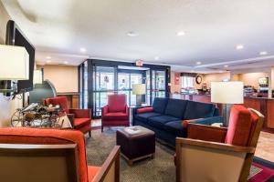 a living room with a blue couch and red chairs at Comfort Inn Washington DC Joint Andrews AFB in Clinton