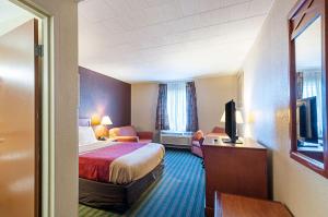 a hotel room with a bed and a television at Quality Inn Near Pimlico Racetrack in Baltimore