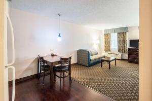 a hotel room with a table and a chair at MainStay Suites Frederick in Frederick