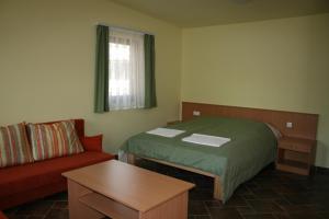 a small room with a bed and a couch at Mátra Kemping Apartmanok in Matrafured