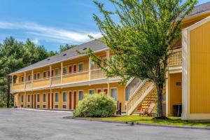 duży żółty budynek z drzewem przed nim w obiekcie Econo Lodge Freeport - Brunswick Area w mieście Freeport