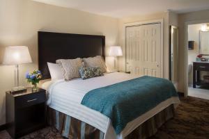 a bedroom with a large bed with a blue blanket at Port Inn & Suites Kennebunk, an Ascend Collection Hotel in Kennebunk