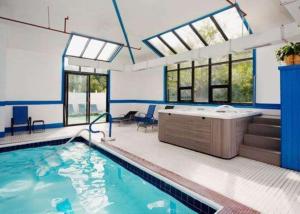 a swimming pool with a tub in a room with windows at Comfort Inn Civic Center in Augusta