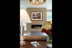 a living room with a couch and a fireplace at Port Inn & Suites Kennebunk, Ascend Hotel Collection in Kennebunk