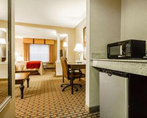 a hotel room with a bed and a desk with a microwave at Comfort Inn & Suites Scarborough in Scarborough