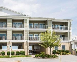 an apartment building with balconies and a tree at Island Inn & Suites, Ascend Hotel Collection in Piney Point