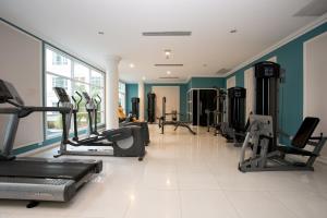 a gym with several treadmills and elliptical machines at Hope Land Hotel 46/1 in Bangkok