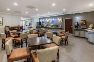 a restaurant with tables and chairs and a kitchen at Comfort Inn College Park North in Beltsville