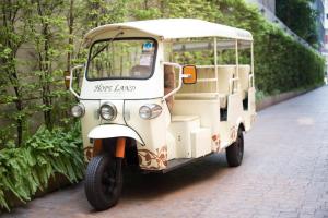 a small white golf cart parked on a street at Hope Land Hotel 46/1 in Bangkok