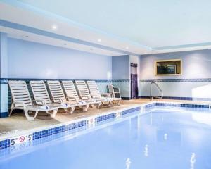 une piscine avec des chaises longues et une piscine dans l'établissement Comfort Inn & Suites Scarborough, à Scarborough