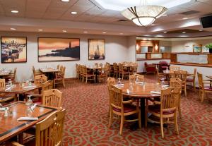 a dining room with wooden tables and chairs at Clarion Hotel Airport in Portland