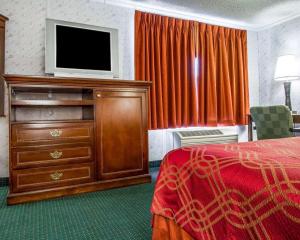 a hotel room with a television and a bed at Rodeway Inn & Suites Brunswick near Hwy 1 in Brunswick