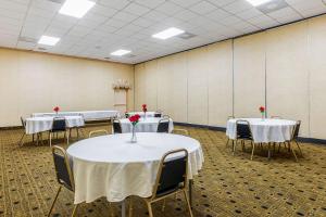 a room with white tables and chairs with red roses on them at Quality Inn & Suites Coldwater near I-69 in Coldwater